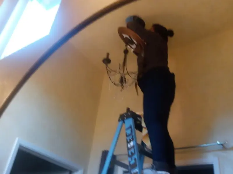 Electrician installing a chandelier in a Menlo Park residence